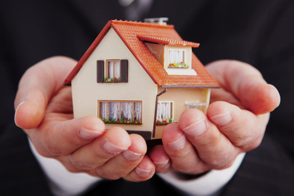 A Yango employee showing a model of a house during a presentation on In-House Programmatic Trading services.